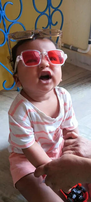 Our little one laughing in pink sunglasses